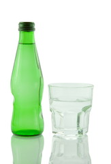 Bottle and glass of mineral water reflected on white background