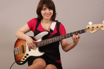 young beautiful woman with a bass guitar