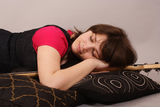 young beautiful woman with a bass guitar - asleep