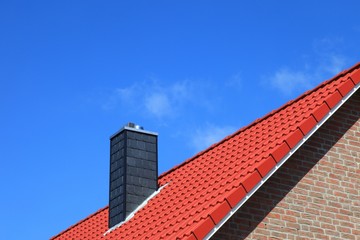 Fototapeta na wymiar Nowy dach komin czerwone dachówki