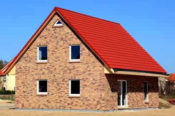 Neubau Einfamilienhaus neutral vor blauem Himmel