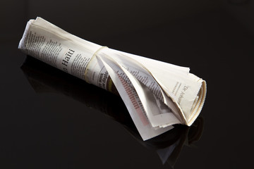 rolled up newspaper on black