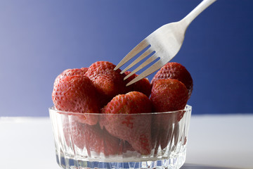 A fork and strawberries.