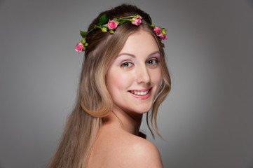 graceful young woman with roses on her head
