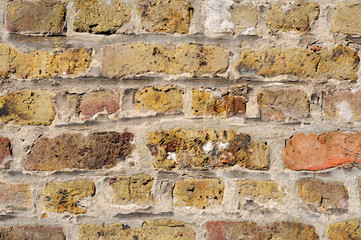 Old brick wall in shades of yellow, ochre, and brown