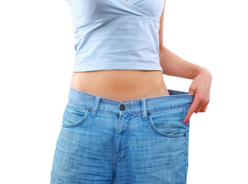 young woman in old jeans pant after losing weight.
