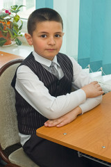 The pupil sits at a school desk
