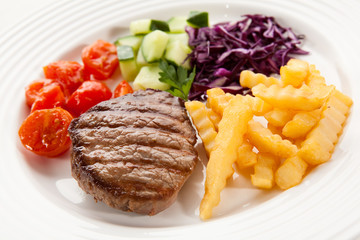 Grilled steak with chips and vegetables