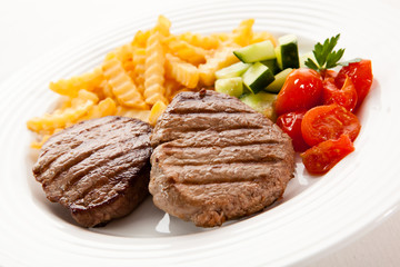 Grilled steaks with chips and vegetables