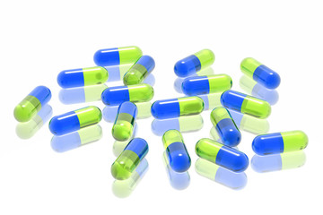 green and blue pills on white background
