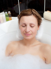 Obraz na płótnie Canvas Beautiful woman relaxing in a bubble bath