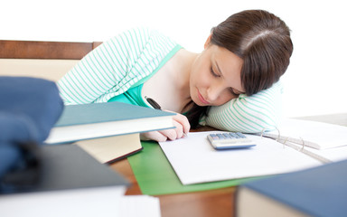 Young tired woman studying on a table