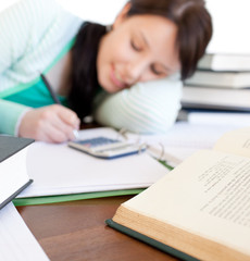 Brunette student doing her homework on a desk