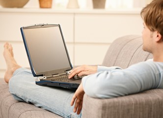Man with laptop on sofa