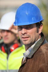 Portrait d'un ouvrier avec un casque de chantier