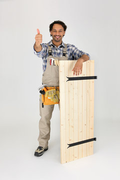 menuisier debout avec un volet en bois