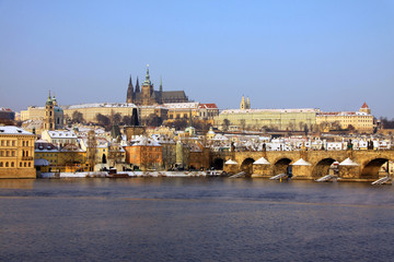 The snowy Prague's gothic Castle with the Charles Bridge