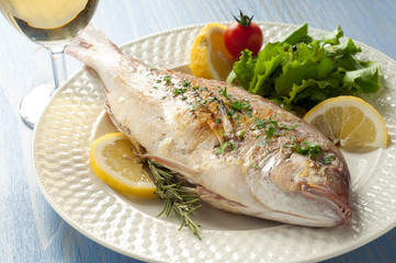 grilled red snapper with salad and glass of white wine
