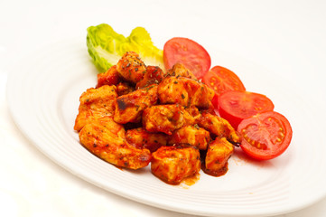 chicken fried in tomato sauce isolated on white
