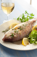grilled red snapper with salad vertical  and glass of wine