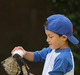 Fototapeta premium Hispanic boy playing with baseball and glove