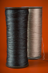 large spools of thread on a red background