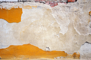 Fragment of tumbledown plastered brick wall