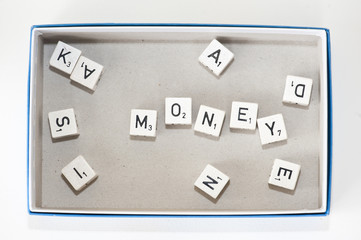 Board game dice spelling out "money"