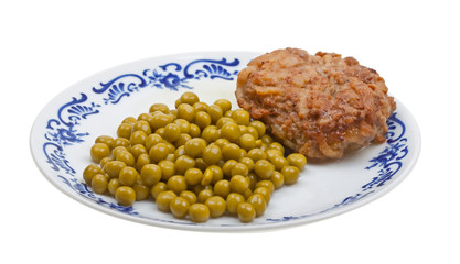 Steak with peas on a plate isolated on white