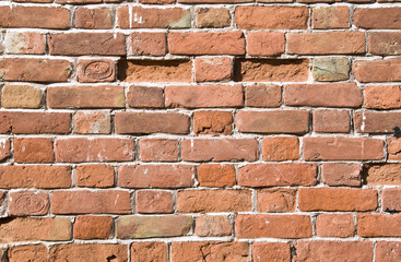 Obraz premium The old brick wall with broken stones.