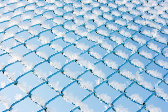 Closeup of fence wirecloth covered with morning hoarfrost