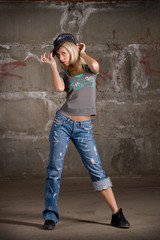 Obraz na płótnie Canvas Beautiful hip hop girl dancing over grey brick wall