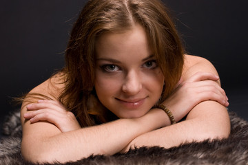 Closeup portrait of young savage woman on fur