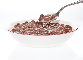 Bowl of milk and chocolate cereal with a spoon © kmiragaya