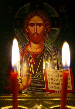 Orthodox icon by the light of two burning candles