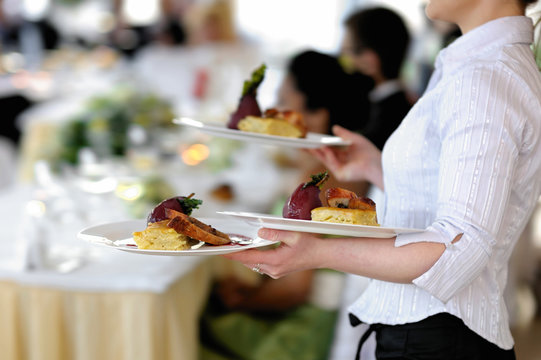 Waitress carrying three plates of delicious food