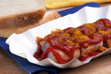 Currywurst mit Ketchup und Curry in einer Schale