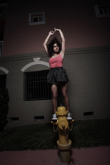 Woman posing on a fire hydrant at night