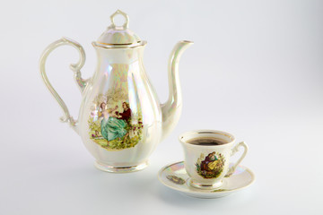 Beautiful old coffee pot and cup with a drawing
