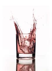 Beautiful splash of ice and pink water in a glass