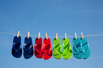 Row of flipflops against a blue sky