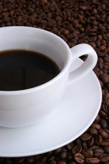 Kaffeebohnen und eine weisse Tasse