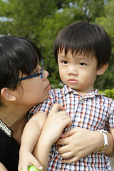 An Asian mother and her son at a park