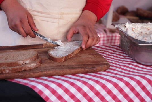 Mann beim Brot schmieren