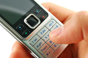 Dialing a mobile phone closeup on a white background.