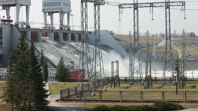 Spring flood water flowing on hydroelectric power station dam