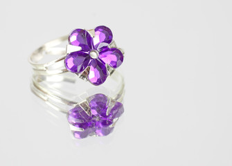 Pretty purple costume jewelry ring on mirrored surface