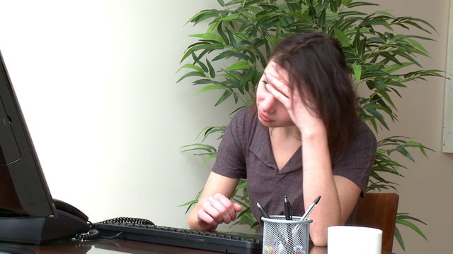 Overwhelmed woman working at a computer at home