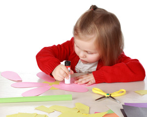 girl playing with paper and glue