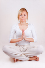 young woman practicing yoga (hands together) separated on white